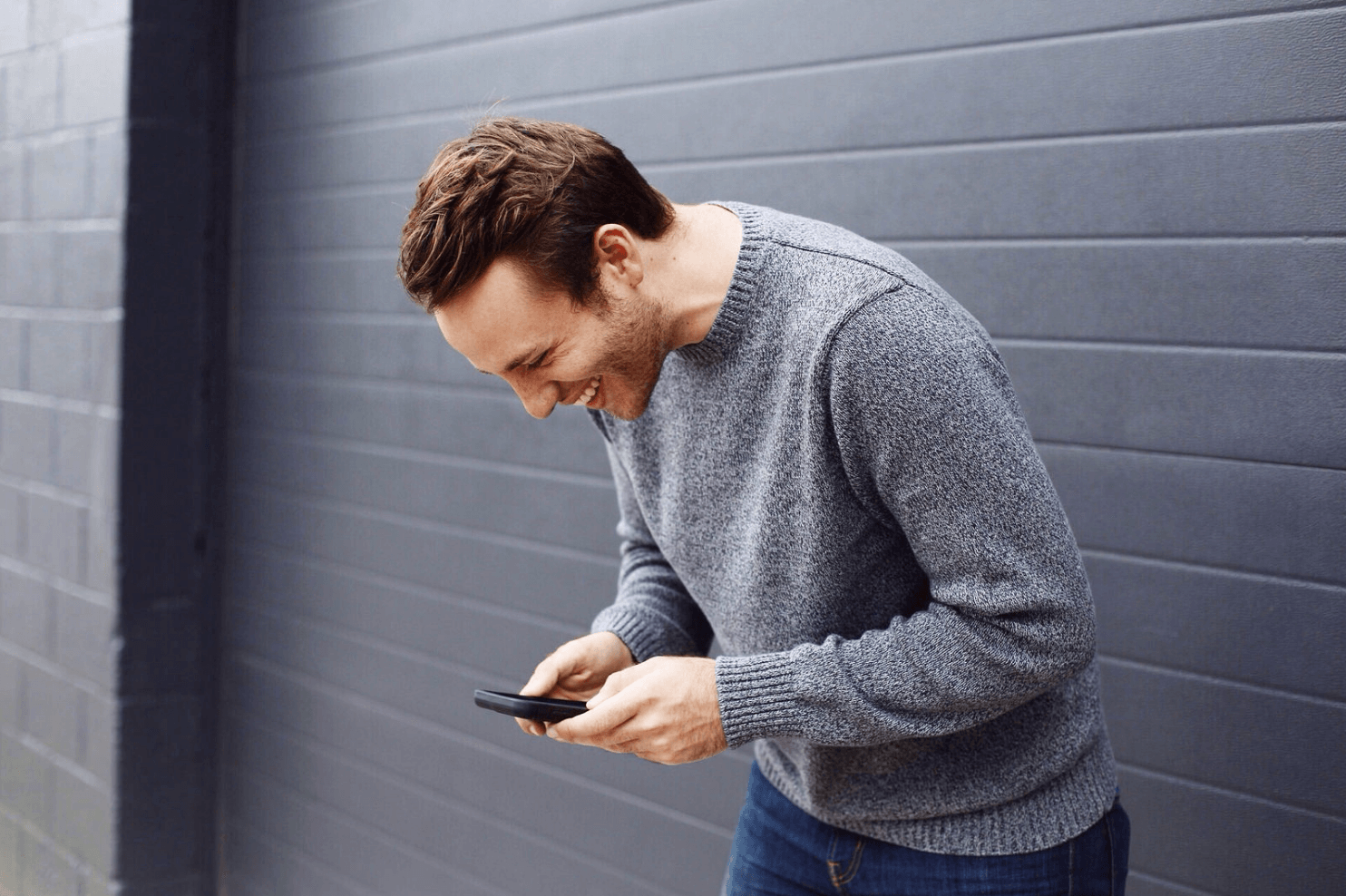 Seorang pria sedang menggunakan smartphone-nya